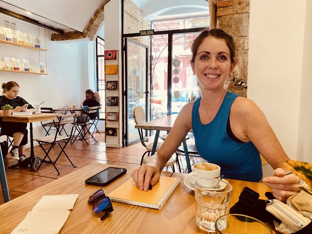 Jenni at a café table with a notebook